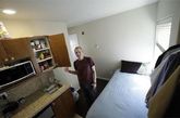 西雅图的一个微型公寓，租户克里斯·金站在厨房里，旁边就是床和开放式衣橱。这座公寓楼地处市中心。他的公寓面积很小，与一个大一点的停车位差不多。最初，克里斯也对如此迷你的公寓感到吃惊。