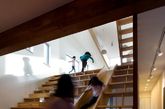 二十、多功能中心楼梯
来自韩国建筑事务所 moon hoon 的设计。设计师在整幢房屋的中心多功能区域中设计了一个巨大的木楼梯，它集书架、阅读角、滑梯和观影座位为一体，创造了一个丰富的室内活动空间。（实习编辑：谭婉仪）