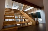 二十、多功能中心楼梯
来自韩国建筑事务所 moon hoon 的设计。设计师在整幢房屋的中心多功能区域中设计了一个巨大的木楼梯，它集书架、阅读角、滑梯和观影座位为一体，创造了一个丰富的室内活动空间。（实习编辑：谭婉仪）