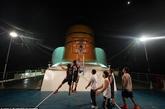 宾客们进入梦乡后，忙碌的员工们终于有了自己的海上悠闲时光，图为员工在昏暗灯光照射下的甲板上打篮球。