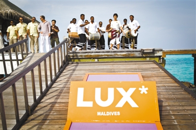 迪娃岛上，LUX酒店的工作人员在海边跳舞迎接游客。