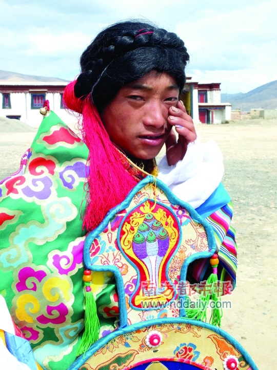 跳藏族舞蹈的藏族青年面对镜头，有点害羞。