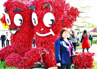 10月12日，在山西省新绛县举办的“一村一品”展交会上，参观者在堆积起来的辣椒造型前拍照留念。
