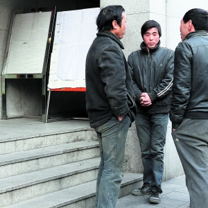 　　2013年1月17日，上海万航渡路77号，一位务工人员（中）在售票窗口前等待购票，但最终并没有买到回老家长春的车票。本版图片 早报记者 王辰
