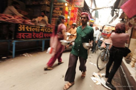 　　印度的新德里　　图为旧德里的一条街上，一名男子正在外送食品。