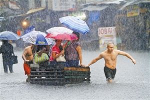 　　菲律宾奎松城一积水路段，两名男子协助几名妇女转移。新华社发