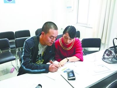 图为贝贝父亲配合工作人员签署遗体器官捐献协议书。（来源：武汉晚报）