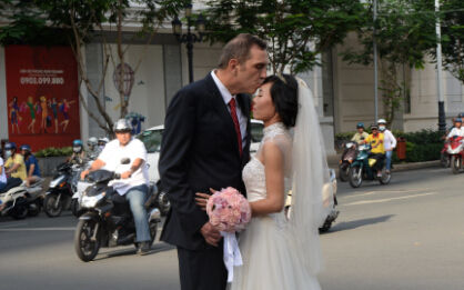 　一名老外與越南新娘在街頭拍婚紗照。據越南官方統計，2008年至2010年三年間，有30萬越南人選擇嫁給外國人，且每年人數都在增長。 