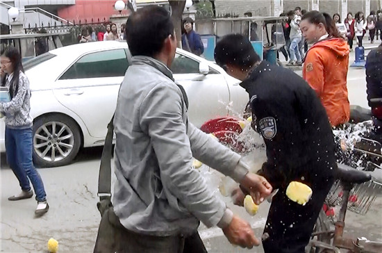 摊贩将菠萝泼向一名城管队员。（视频截图）