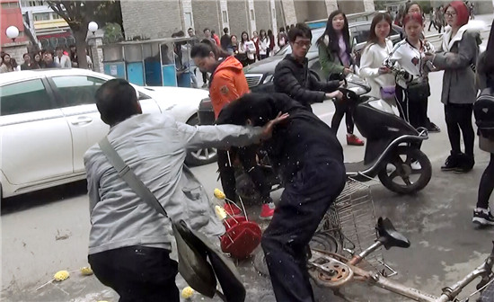 摊贩推倒一名城管队员。（视频截图）