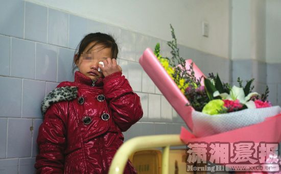 12月6日，长沙市传染病医院，小倩化名的妹妹站在病床前暗自落泪。图/潇湘晨报记者谢长贵