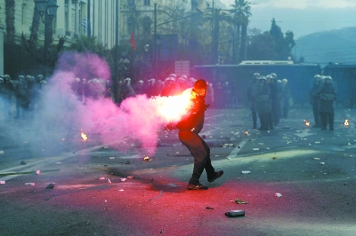 12日,在雅典市中心议会附近的示威活动中,示威者向防暴警察投掷烟雾弹