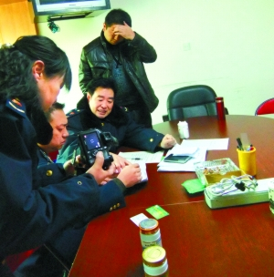 　　工商执法人员现场调查，记者拍照时老板(右一)遮住了脸。