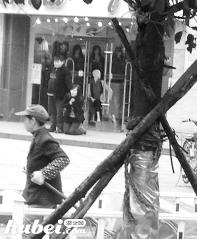黑衣男子持刀将女子挟持。图片来源于网络