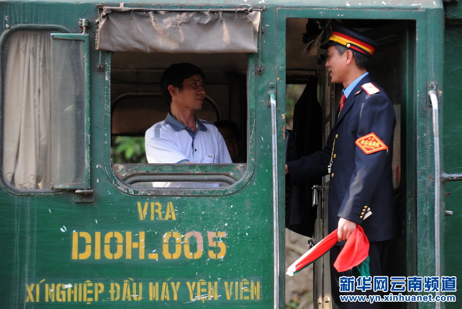 3月6日,王学义(右)和经过河口站的越南火车司机交谈。新华社记者 秦晴 摄