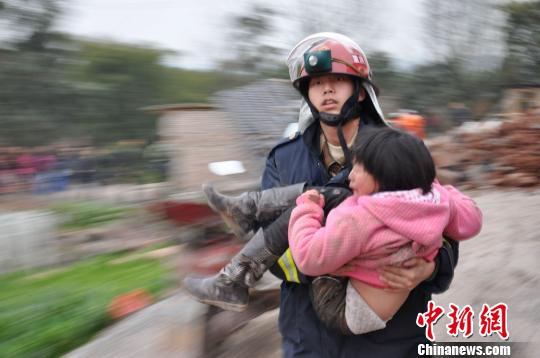 图为消防战士救出一名孩子。　朱兴强　摄