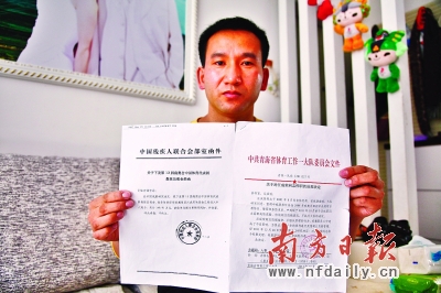 汪成荣展示中残联向其发放奖金的书面通知和由青海省体工一大队委员会发出的《关于对汪成荣同志停职的处理决定》。