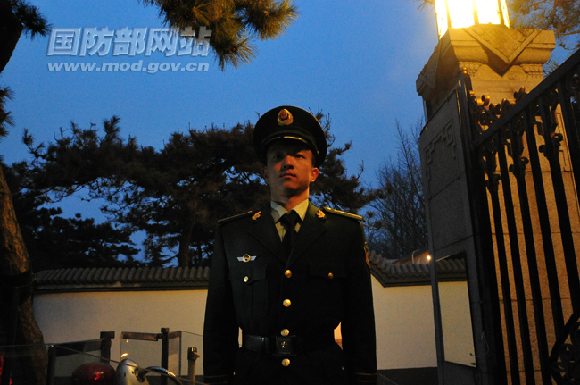 华灯初上,站在哨岗上的他军容严整,神态庄重。