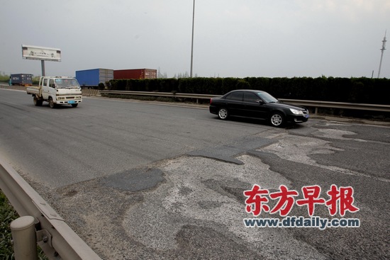 昨天,位于A30(目前叫G1501郊区环线高速公路)北段外圈浏翔公路出口附近大片路面坑洼不平,车辆必须减速慢行。早报记者 张栋 图