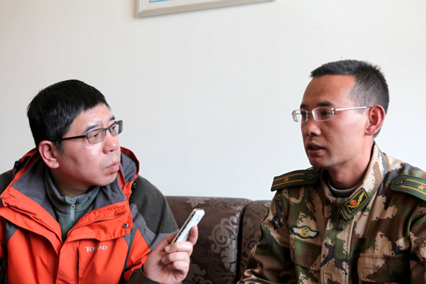 记者李洪涛采访科加边防派出所参谋孙振庆。(记者郭璇 摄)
