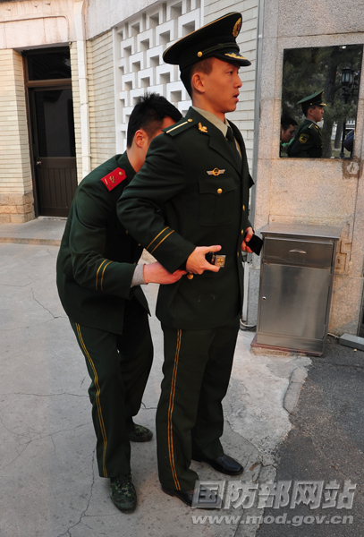 出岗前,细心的班长看到东桦的腰带不是很标准,于是重新帮他整理。