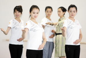 50位明眸皓齿的美女大学生在礼仪培训师的指导下,认真地练习着各种