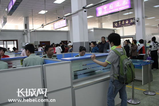 　　新版的电子护照5月15日启用。图为5月17日一位正在办理相关手续的游客，执勤人员在为他介绍相关情况。徐非 摄