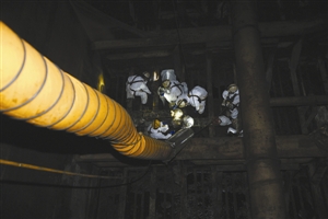 清污工人沿梯下到漆黑的舱里。