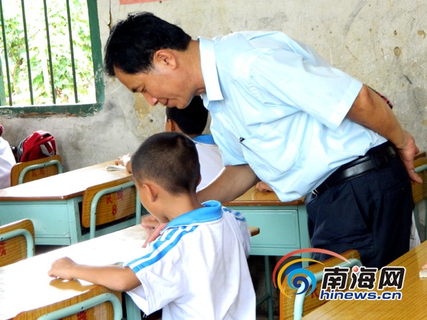 屯昌乌坡中心小学民族教学点,三个年级孩子在一间屋子上课,李修雄老师正在为孩子答疑解惑。(南海网实习生谭邦会摄)