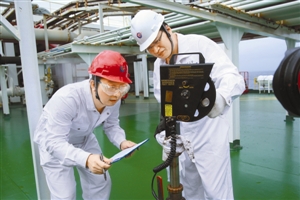 肖天智和罗智在油轮上采取油样。