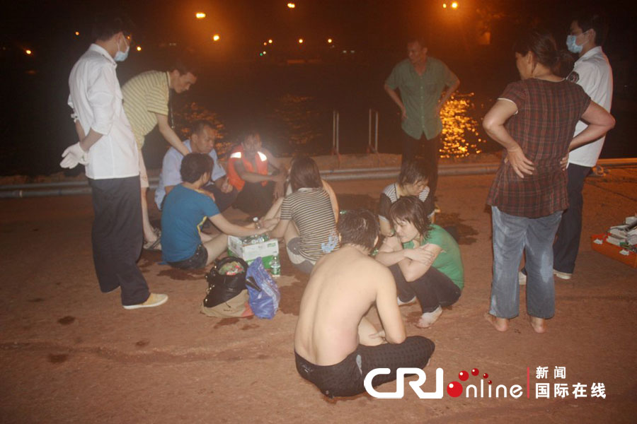 2012年7月8日早晨,深圳蛇口港码头发生偷渡人员落水事件,目前已经有9人获救,还有3人失踪。救助局的工作人员为刚被救出来的偷渡者送来了水。图片来源:cfp