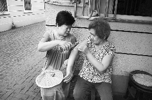 飘香百年,花露水已成为人们度夏的必备品。在上海人的记忆中,花露水是夏天驱蚊的首选。 昨天傍晚,静安区威海路910弄,两位居民正在弄堂里涂花露水。 早报记者 高征 实习生 庄晓丹 图