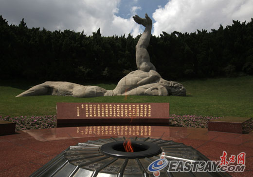 龙华烈士陵园绿草环绕的“无名烈士”雕像和熊熊燃烧的长明火。这里长眠着700多位烈士。