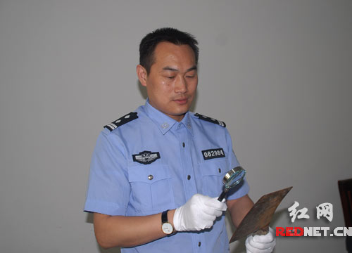 (唐战雄正在研究案情。)