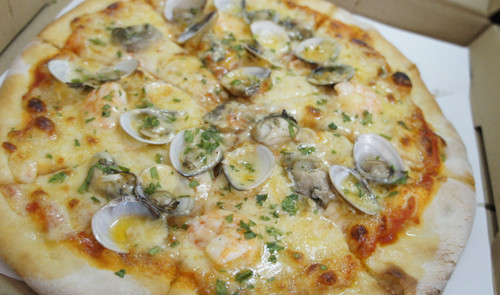 Sandro手工披萨店用料实在，到7月底前披萨一律新台币200元，外带打九折。图片来源：台湾《联合报》