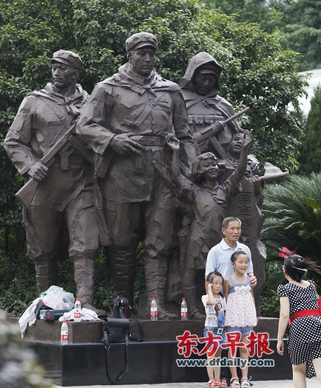 游客在“南京路上好八连”主雕塑前留影。