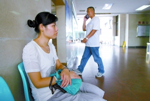 　　市急救中心，郭女士在医院等待检查结果，司机（后打电话）万先生焦急地给保险公司打电话。 记者 王海 摄