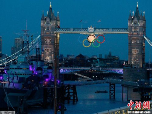 当地时间8月3日，伦敦塔桥上出现了令人称奇的一幕，一轮满月顺着塔桥的五环升起，与奥运五环一起组成了“奥运六环”，而随着月亮慢慢升起，它也完成了对五环的“穿越”。