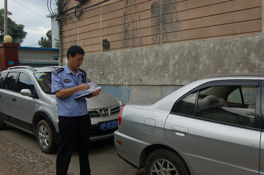 在社区巡逻时发现一辆未关车窗的汽车,记下车号联系车主高清图片