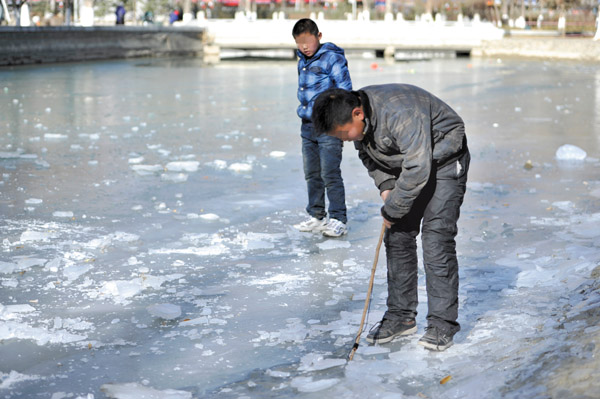 拉萨市区内公园人工湖湖面封冻孩童玩耍隐藏危