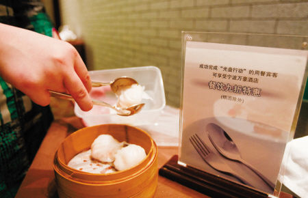 餐厅服务员在为客人打包剩菜。记者唐严摄