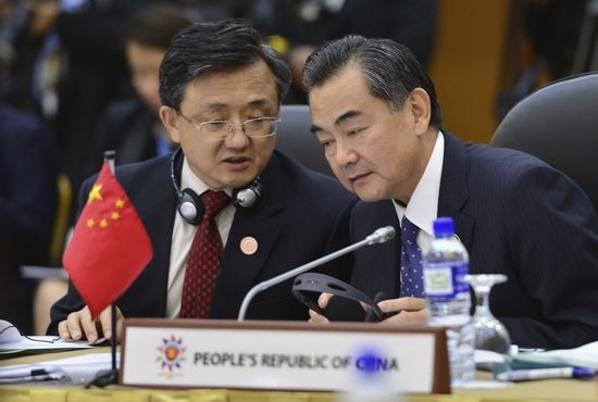 长会的中国外长王毅(右)与副外长刘振民低声交
