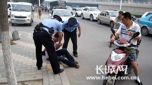 天津:男子醉卧路边阻交通 民警救助送其回家