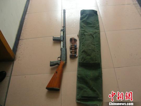 图为查获的一把来福枪和五发子弹