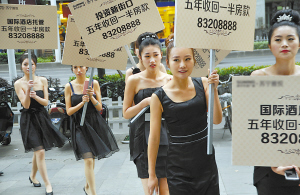 图为美女举牌在南京新街口促销楼盘.本报记者余萍摄