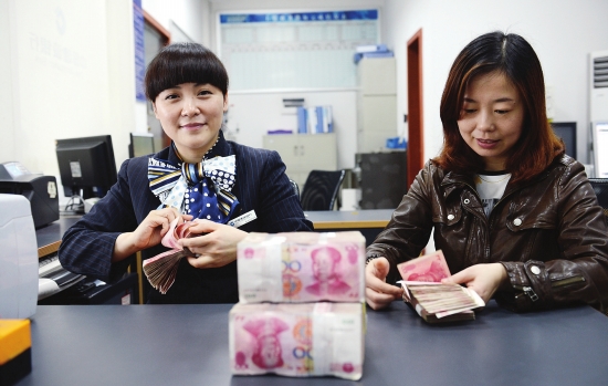 4月25日,中国建设银行长沙马坡岭支行,本报记者向点钞能手王雪艳(左)