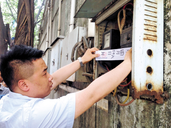 执法人员在排污企业的电表上贴封条