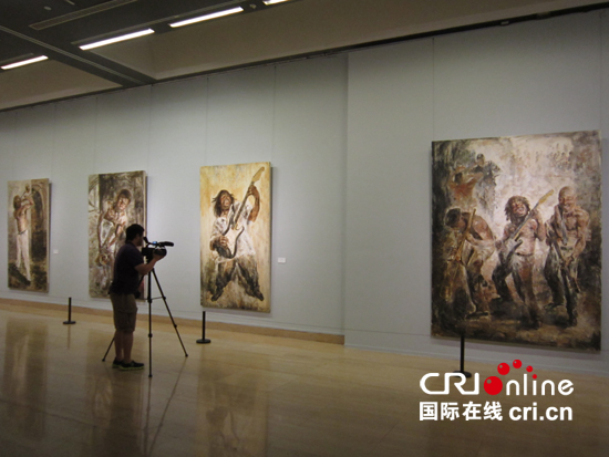 展览现场展厅中,画家王鑫生(左一)在与喜爱画画的残疾观众交流国际