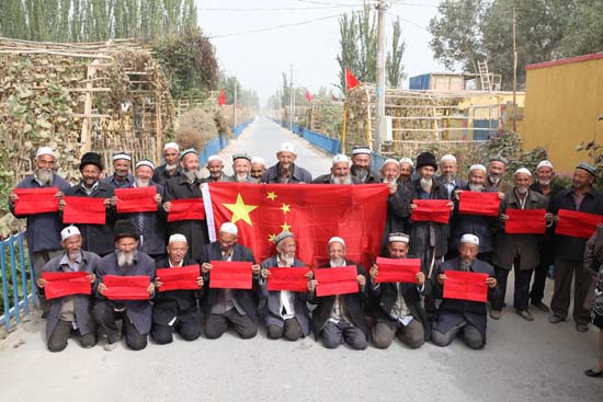 新疆麦盖提县乌依鲁克村举行"祖国在我心中,我与国旗合影"活动