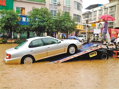 10日,梁平县城,拖车救援被淹车辆.